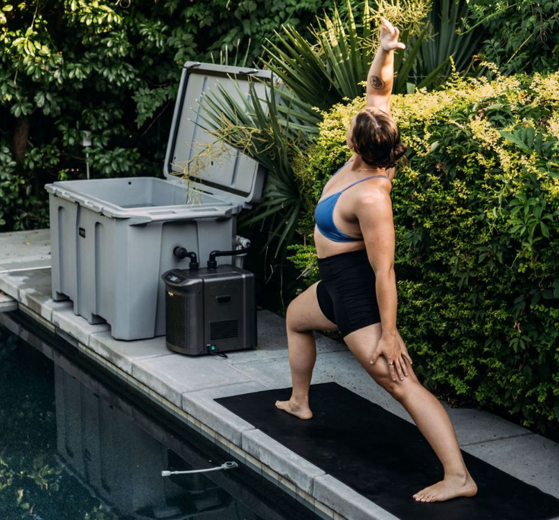Woman preforming yoga near cold plunge tub